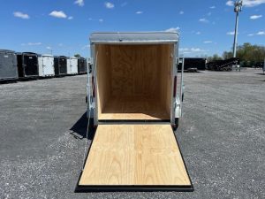 a Car Mate trailer with the door open parked in a gravel lot