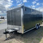 a black trailer with a ladder on the back is parked on the side of the road .