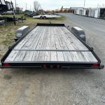 a big tex trailer with a wooden deck is parked on the side of the road .