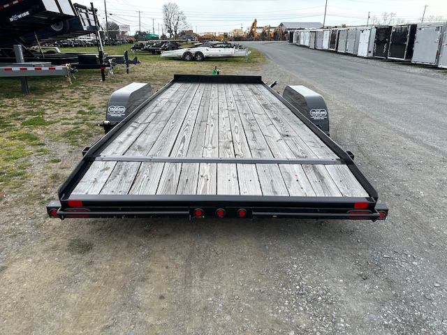 a big tex trailer with a wooden deck is parked on the side of the road .