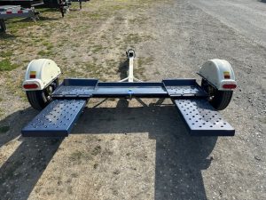 a master tow trailer parked on the side of a dirt road .
