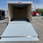 a trailer with a ramp is parked in a gravel lot .